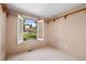 Cozy bedroom with neutral tones, shuttered window offering a serene view of the surrounding landscape at 27124 Sun Ridge Dr, Evergreen, CO 80439