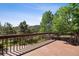 Wooden deck overlooking a stunning landscape with trees and hills provides the perfect outdoor retreat at 27124 Sun Ridge Dr, Evergreen, CO 80439