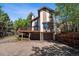 Two-story home showcasing a beautiful deck above the garage and mature landscaping at 27124 Sun Ridge Dr, Evergreen, CO 80439