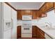 Efficient kitchen layout featuring wooden cabinets and white appliances at 27124 Sun Ridge Dr, Evergreen, CO 80439