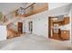 Spacious living room with a grand staircase, seamlessly connecting to the kitchen and entry at 27124 Sun Ridge Dr, Evergreen, CO 80439