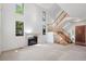 Sunlit living room boasts high ceilings, a fireplace, a striking staircase, and front door access at 27124 Sun Ridge Dr, Evergreen, CO 80439