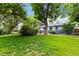 Lush green backyard with mature trees, offering shade and privacy for outdoor enjoyment at 3317 W Belmont Ave, Littleton, CO 80123