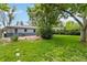 Spacious backyard with lush green lawn, mature trees, and a lovely patio area at 3317 W Belmont Ave, Littleton, CO 80123