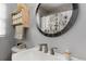 Bathroom sink featuring a modern faucet, flower curtain, and decorative storage at 3317 W Belmont Ave, Littleton, CO 80123