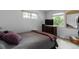 Bedroom with large windows, comfortable bed, and a dresser with a television at 3317 W Belmont Ave, Littleton, CO 80123