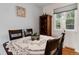 Cozy dining room with hardwood floors, a white table cloth, and natural light from the window at 3317 W Belmont Ave, Littleton, CO 80123