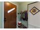 Home entryway with wood door, coat rack, decorative art and adjacent hallway at 3317 W Belmont Ave, Littleton, CO 80123