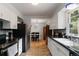 Galley kitchen with white cabinets, stainless steel fridge, and view into dining area at 3317 W Belmont Ave, Littleton, CO 80123
