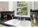 Close-up of the kitchen sink and window with patterned backsplash at 3317 W Belmont Ave, Littleton, CO 80123