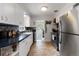 Bright kitchen featuring white cabinets, stainless steel appliances, and tile backsplash at 3317 W Belmont Ave, Littleton, CO 80123