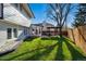 Lush backyard featuring green grass, mature trees, patio area, and house exterior with well-kept landscaping at 6787 E Exposition Ave, Denver, CO 80224