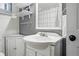 Traditional-style bathroom with white vanity, sink, and elegant white frame mirror and shelves at 6787 E Exposition Ave, Denver, CO 80224