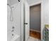 Bright bathroom featuring a shower-tub combo, white tiles, and a granite countertop with under-sink storage at 6787 E Exposition Ave, Denver, CO 80224