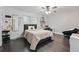 Well-lit bedroom with hardwood floors, a comfortable bed, desk, chair and windows for natural light at 6787 E Exposition Ave, Denver, CO 80224
