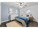 Cozy bedroom featuring a ceiling fan, light blue accent wall, wood floors, and a comfortable bed at 6787 E Exposition Ave, Denver, CO 80224