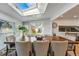 Sunlit dining room with skylight, large wood table, and views to backyard and staircase at 6787 E Exposition Ave, Denver, CO 80224
