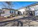 Well-maintained house featuring a brick facade, front porch with seating, and attached two-car garage at 6787 E Exposition Ave, Denver, CO 80224