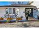 Inviting front porch with seating, planters, modern door with decor, and well-maintained facade at 6787 E Exposition Ave, Denver, CO 80224