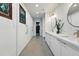 A long hallway featuring built in storage, recessed lighting, and a view of a bathroom at the end at 6787 E Exposition Ave, Denver, CO 80224
