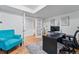 A cozy home office with hardwood floors, modern desk, and bright blue accent chair at 6787 E Exposition Ave, Denver, CO 80224