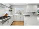 Bright kitchen with stainless steel gas range, plentiful white cabinets and views to the backyard at 6787 E Exposition Ave, Denver, CO 80224