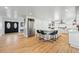 Bright, open kitchen boasts an island with seating, stainless steel appliances, and hardwood floors at 6787 E Exposition Ave, Denver, CO 80224