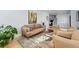 Bright living room with modern decor, neutral-toned furniture, hardwood floors, and a staircase view at 6787 E Exposition Ave, Denver, CO 80224