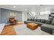 Comfortable living room with hardwood floors, a large sectional sofa, and a decorative rug at 6787 E Exposition Ave, Denver, CO 80224