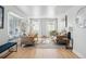 Sun-filled living room with hardwood floors, neutral decor, comfortable seating, and a large bay window at 6787 E Exposition Ave, Denver, CO 80224