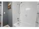 An all-white tiled shower and tub combo featuring modern fixtures and a clean design at 6787 E Exposition Ave, Denver, CO 80224