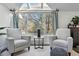 Bright sitting area with modern grey chairs, a small table, and a large window overlooking the yard at 6787 E Exposition Ave, Denver, CO 80224