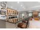 An entertainment bar area with granite counters, wood cabinets, and seating, flowing into a cozy living space at 3358 Castle Butte Dr, Castle Rock, CO 80109