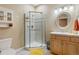 A well-lit bathroom with a glass-enclosed shower, vanity with storage, and neutral tile flooring at 3358 Castle Butte Dr, Castle Rock, CO 80109