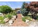Inviting home entrance featuring a decorative walkway, stone accents, and lush landscaping at 3358 Castle Butte Dr, Castle Rock, CO 80109