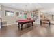 A spacious game room with a pool table, hardwood floors, and a decorative chandelier at 3358 Castle Butte Dr, Castle Rock, CO 80109