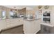 Open-concept kitchen with granite countertops, a large island, and views of the living area with stone fireplace at 3358 Castle Butte Dr, Castle Rock, CO 80109