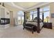 Stunning main bedroom featuring a fireplace, four-poster bed, and scenic views at 3358 Castle Butte Dr, Castle Rock, CO 80109