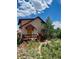 Inviting home with a colorful front deck, American flag, and lush surrounding greenery at 347 Buena Vista Ave, Palmer Lake, CO 80133