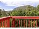 View from red deck overlooking treetops and a distant mountain at 347 Buena Vista Ave, Palmer Lake, CO 80133