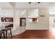 Open kitchen with cherry cabinets, stainless steel appliances, and a breakfast bar overlooking the living room at 1249 S Irving St, Denver, CO 80219