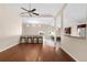 Open-concept living room featuring hardwood floors, a ceiling fan, and a breakfast bar area at 1249 S Irving St, Denver, CO 80219