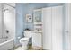 The bathroom features blue walls, a toilet, vanity, mirror and built-in linen closet at 4151 Zenobia St, Denver, CO 80212