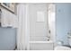 Bathroom features a white tiled shower and tub combination with modern fixtures and blue accents at 4151 Zenobia St, Denver, CO 80212