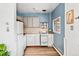 Cozy kitchen showcases blue walls, light wood floors, and functional white appliances and cabinetry at 4151 Zenobia St, Denver, CO 80212