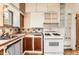Cozy kitchen with unique tile countertops, wood cabinets, white appliances, and natural light at 4151 Zenobia St, Denver, CO 80212