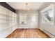 Bright living room with hardwood floors, large windows, custom built-in shelving and traditional chandelier at 4151 Zenobia St, Denver, CO 80212