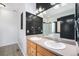 Double vanity bathroom with dark tile and a shower at 851 Lonewolf Cir, Lochbuie, CO 80603