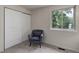 Cozy bedroom featuring a stylish chair, sliding closet doors, and a view of outside at 17605 Ponderosa Ave, Parker, CO 80134