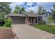 Lovely house with a brick and siding exterior, a two-car garage, and nice landscaping at 17605 Ponderosa Ave, Parker, CO 80134